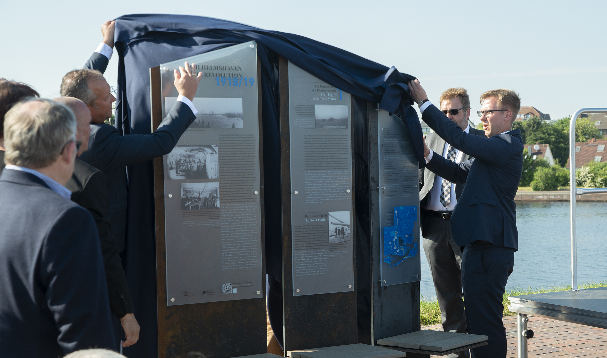 Enthüllen den Informationsparcours: Oberbürgermeister Andreas Wagner (links), Museumsmitarbeiter Daniel Hirschmann (rechts) und Museumsleiter Dr. Stephan Huck (rechts im Hintergrund). Foto: Deutsches Marinemuseum / Torsten Wieland